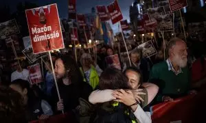 Dos mujeres se abrazan durante una manifestación que recorre las calles de València para exigir la dimisión de Carlos Mazón.