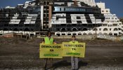 Una veintena de activistas de Greenpeace escriben 'Demolición' frente al hotel del Algarrobico