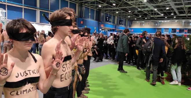 El movimiento Extinction Rebellion se desnuda ante el 'stand' de Endesa en la COP25