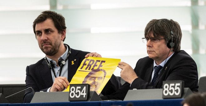 Puigdemont y Comín muestran un cartel de Junqueras durante su estreno en el Parlamento Europeo