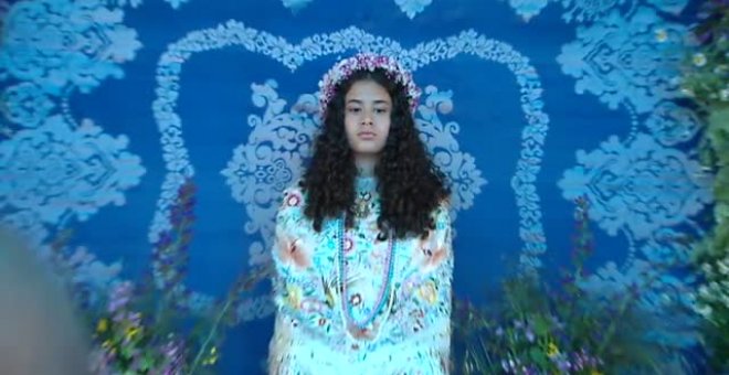 Niñas en un altar rodeadas de flores en la fiesta de La Maya de Colmenar Viejo