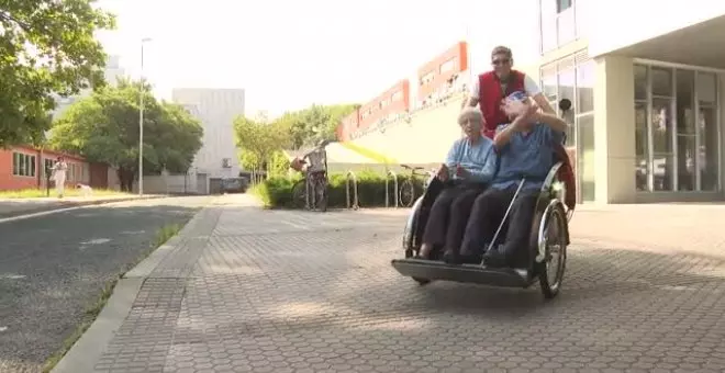 Un grupo de voluntarios pasea a ancianos de residencias de San Sebastián en triciclos