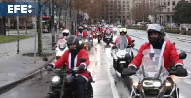 Moteros disfrazados de Papá Noel llevan regalos a niños en Belgrado