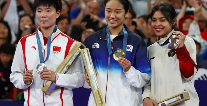 La deportista china He Bingjiao recoge su medalla con un pin con la bandera de España en homenaje a Carolina Marín