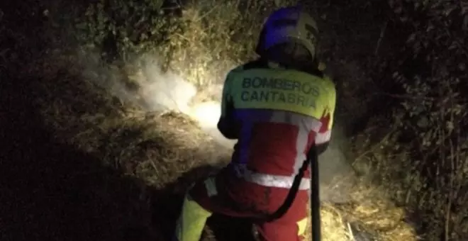 Bomberos sofocan un fuego en una pila de paja junto a una torre eléctrica en Cayón